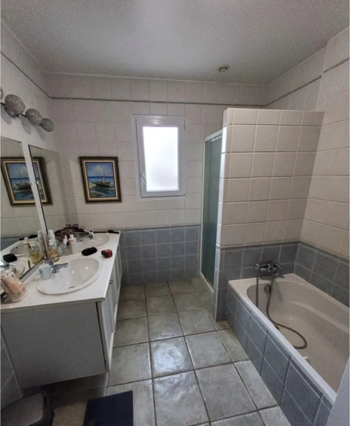 Salle de bains avant rénovation : baignoire et double vasque